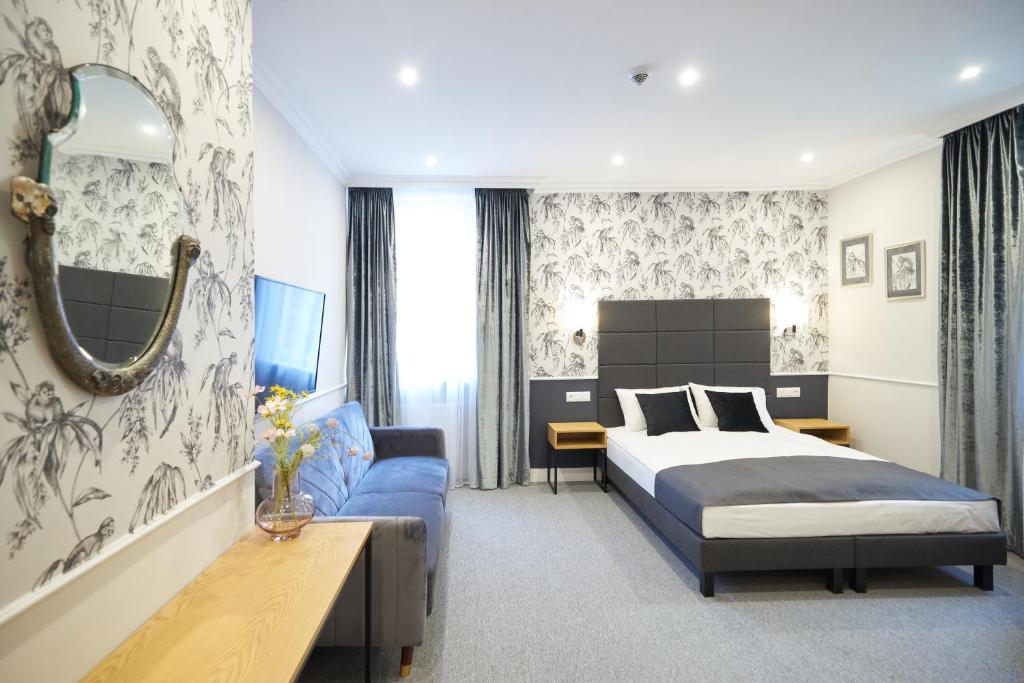 波兹南Apartamenty Klasztorna 25的一间卧室配有一张床和一张蓝色的沙发
