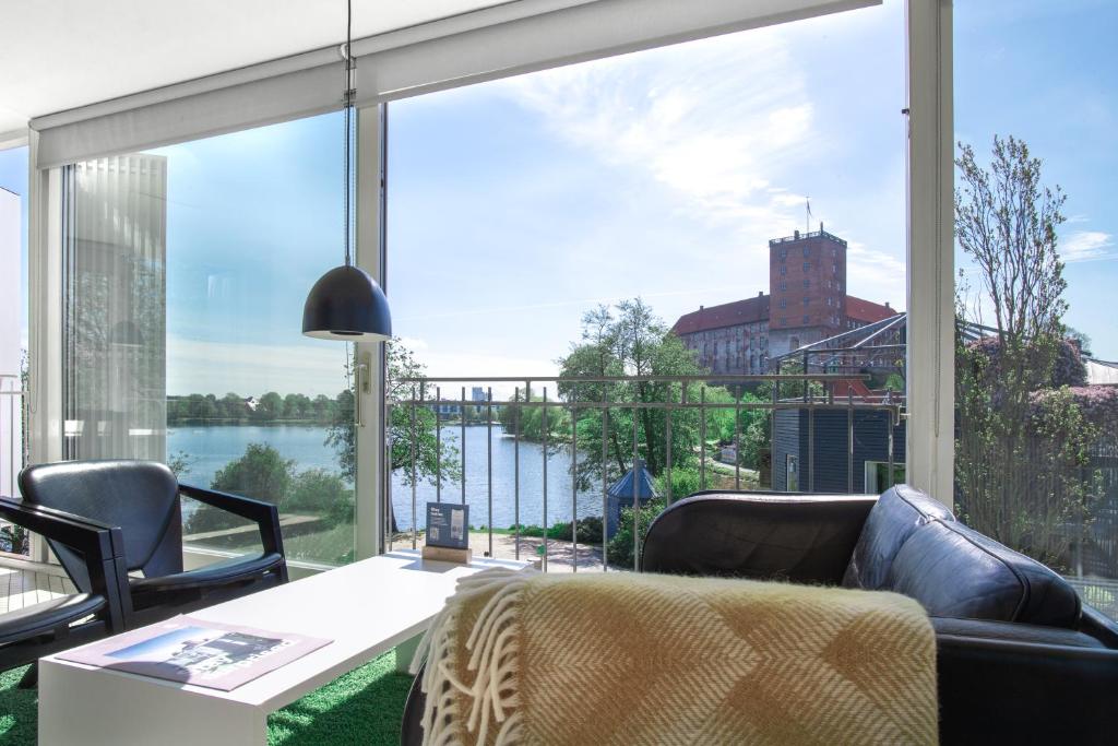 科灵科灵酒店式公寓的客厅设有俯瞰水面的大窗户