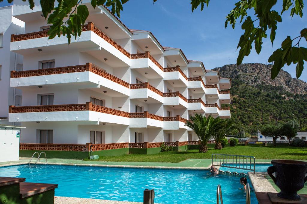 埃斯塔蒂特RVHotels Apartamentos El Quijote的一座建筑前面设有游泳池
