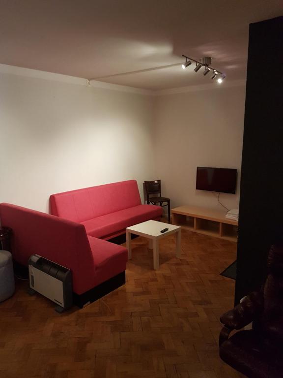 克里斯蒂安斯塔德Hotell Kong Christian的客厅配有红色沙发和电视