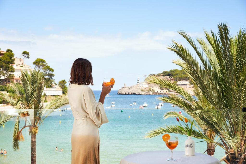索列尔港Hotel Boutique Minister 4Sup的一位戴着酒杯俯瞰海滩的女人
