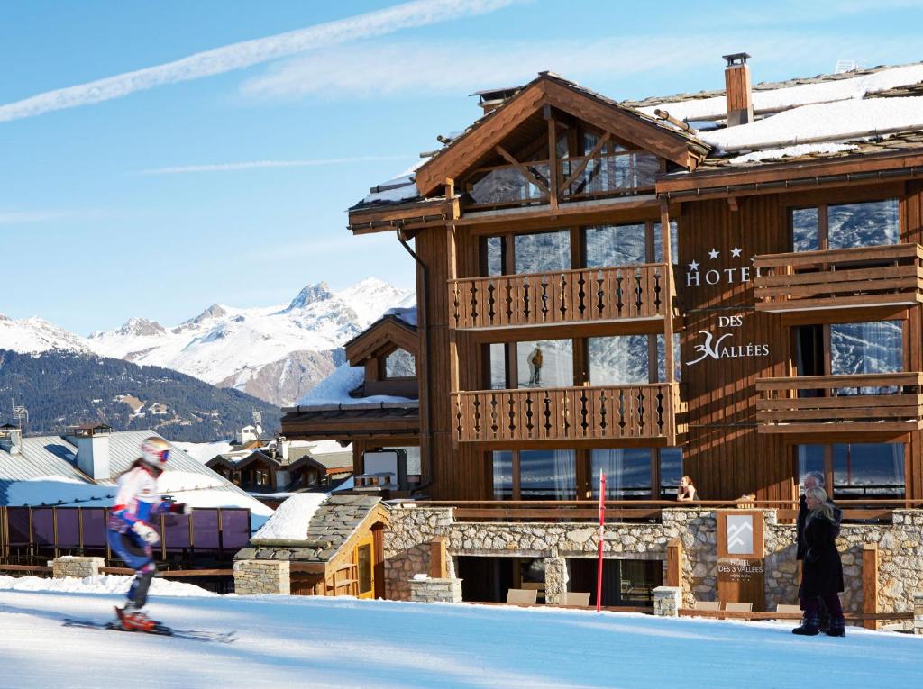 谷雪维尔Les Trois Vallées, a Beaumier hotel的几人在酒店门前滑雪