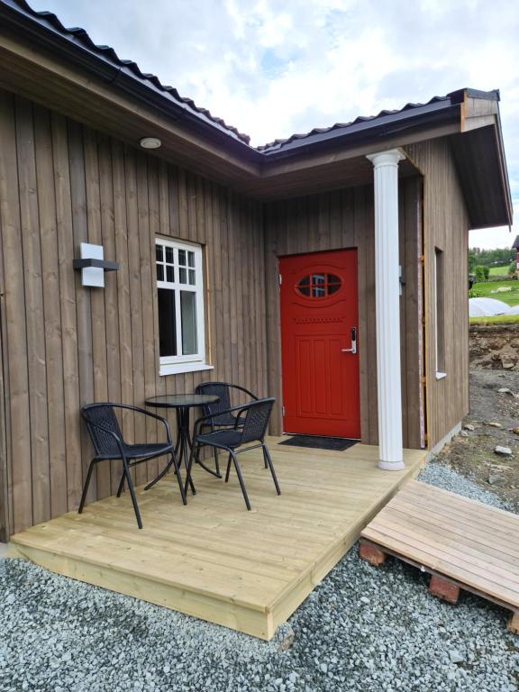 SvensbyAurora Dream的一个带桌椅的庭院和一扇红色的门