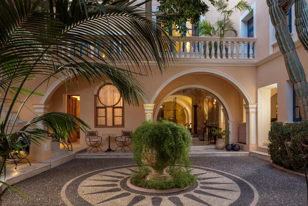 干尼亚卡萨德尔斐诺温泉酒店的一座庭院,在一座建筑里种有棕榈树