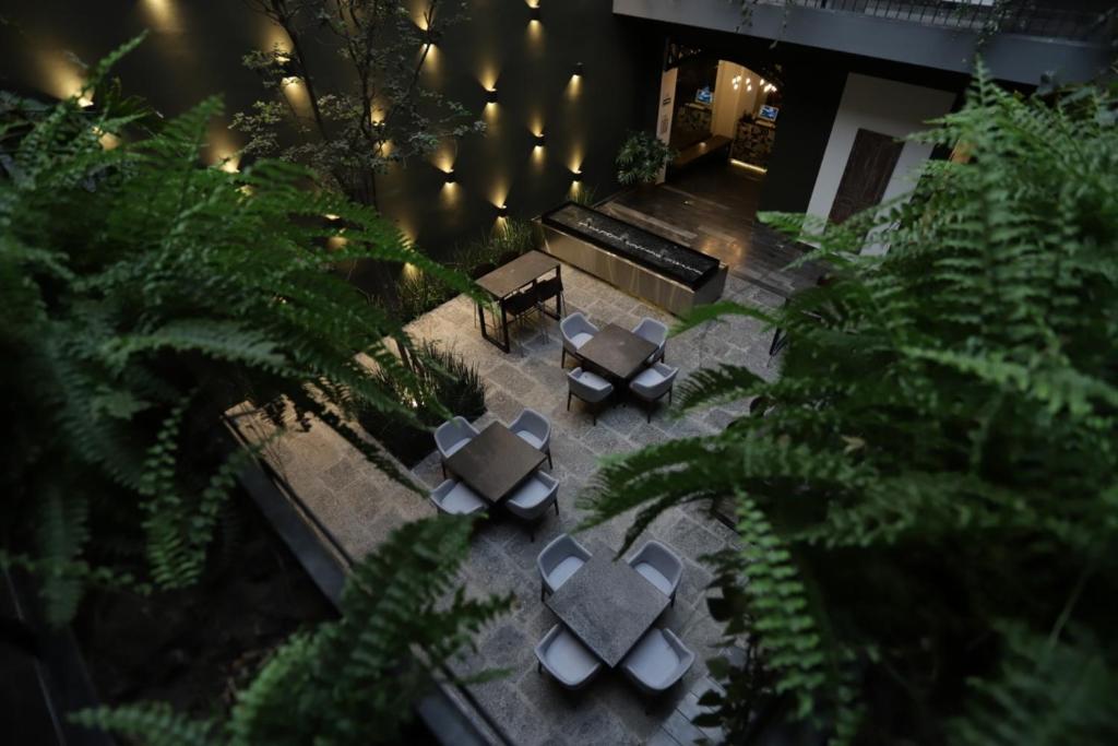 普埃布拉Hotel Isabel的享有带桌子和长凳的天井的顶部景致。