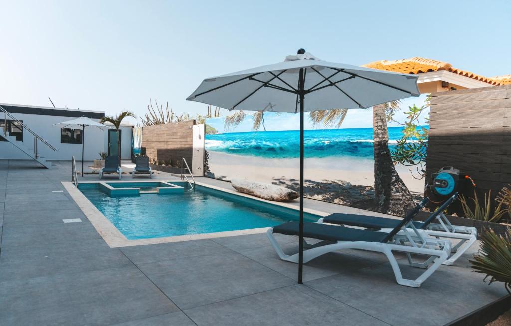 棕榈滩Gray Door Apartments - Adults only的一个带遮阳伞和躺椅的游泳池以及游泳池
