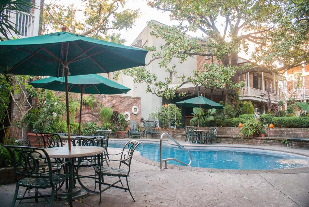 新奥尔良普雷斯迪阿梅斯酒店的游泳池旁配有遮阳伞的桌椅