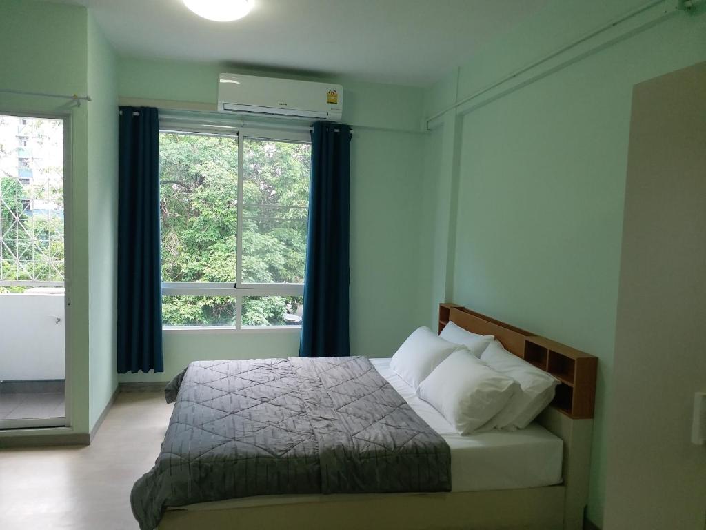 曼谷DD Garden Apartment 2的一间卧室设有一张床和一个大窗户