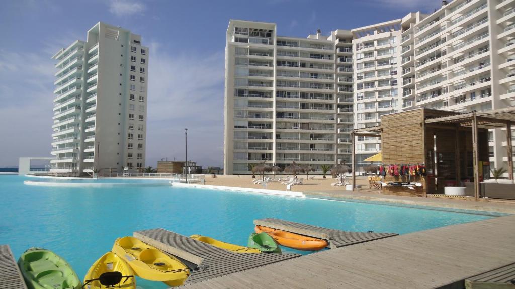拉塞雷纳Resort Urbano Laguna del Mar的一座游泳池,其前方设有皮划艇和躺椅