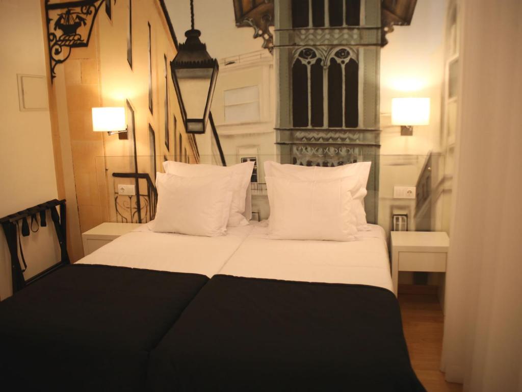 里斯本里斯本风格酒店的一间卧室配有带白色床单和枕头的床。