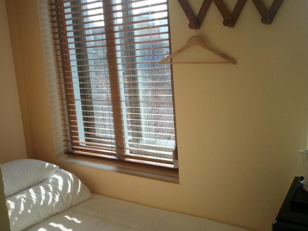 首尔清溪酒店的一间卧室设有窗户、一张床和一个衣架