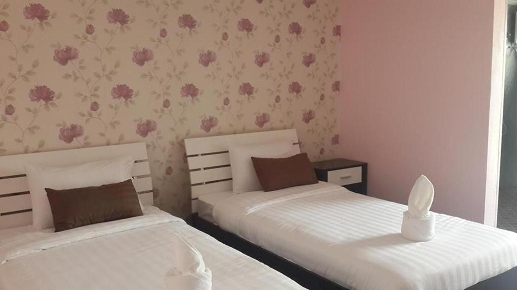 拉廊纳林酒店的卧室内的两张床,墙上挂着粉红色的鲜花