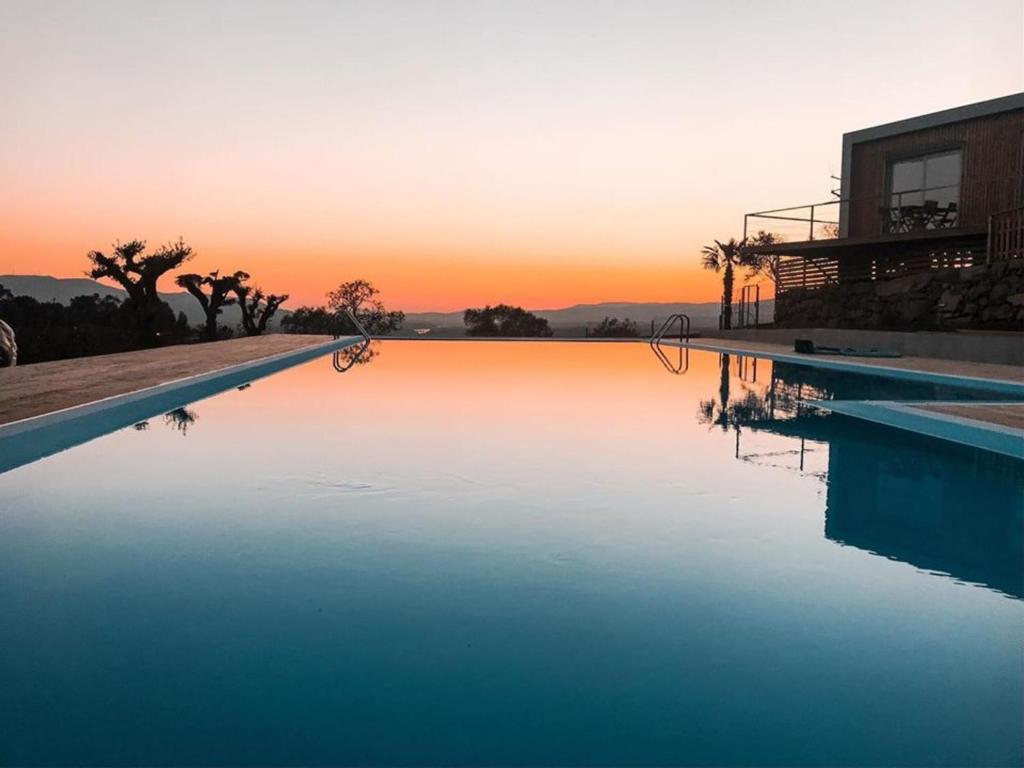 巴伦西亚MyStay - Bungalows in Quinta dos Sobrais的一座享有日落美景的游泳池