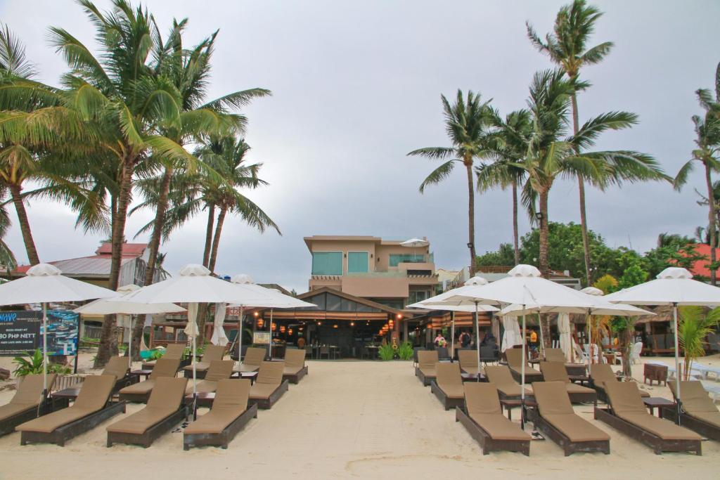 长滩岛两季长滩岛度假酒店的海滩上设有椅子和遮阳伞,棕榈树