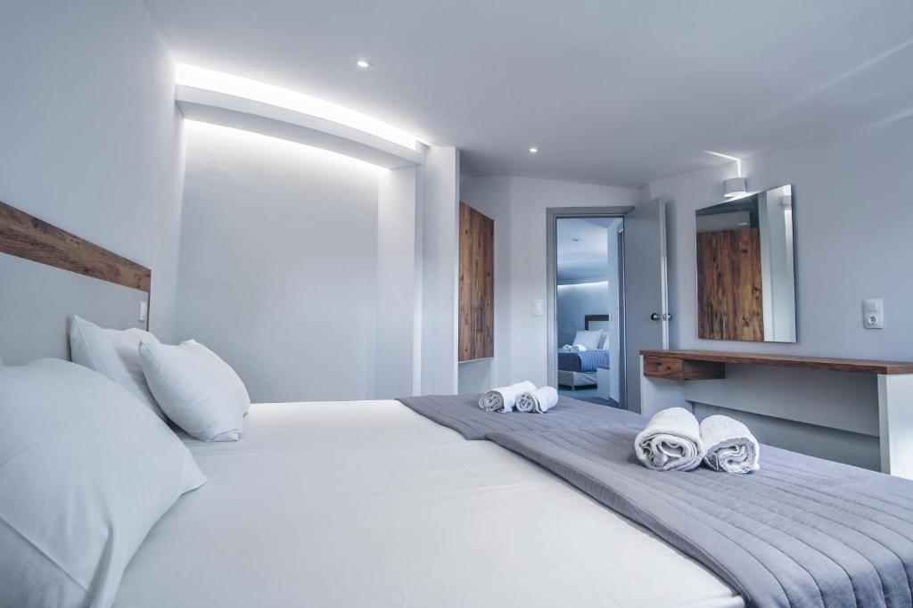 卡沃斯Island Kavos的卧室配有带毛巾的大型白色床