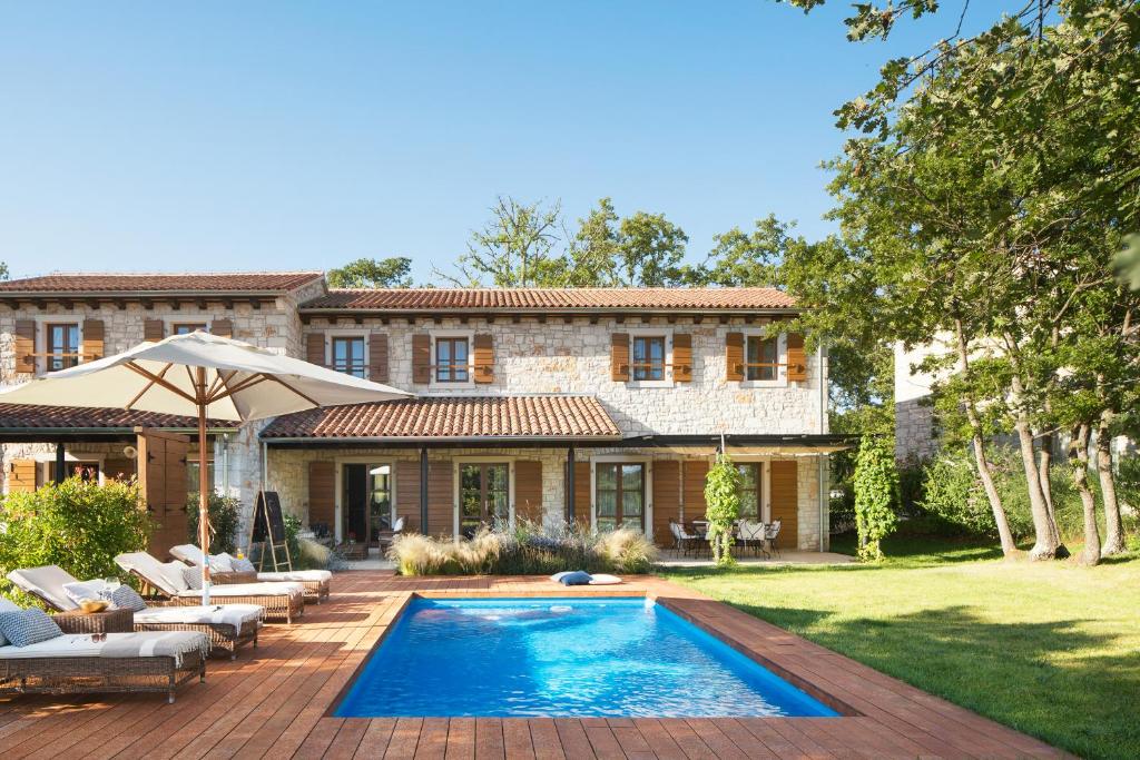 巴莱Meneghetti Wine Hotel and Winery - Relais & Chateaux的庭院中带游泳池的房子
