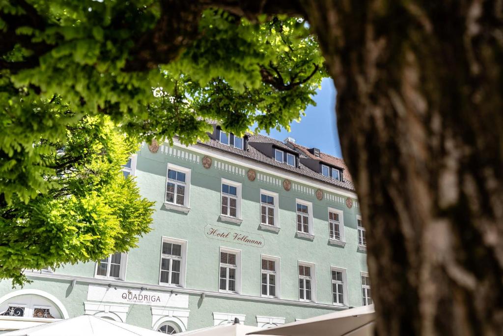 上巴伐利亚魏尔海姆沃尔曼酒店的一座蓝色的大建筑,拥有白色的窗户和树木