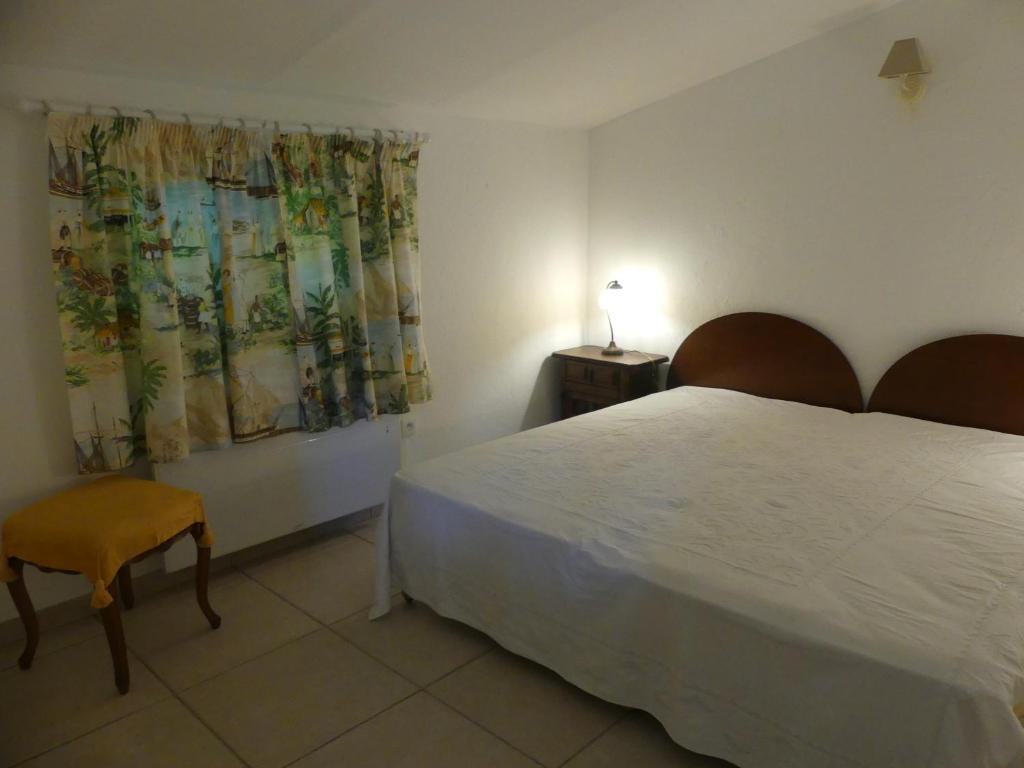 曼德琉-拉纳普勒Maisonnette au calme et proche mer的卧室配有白色的床和椅子