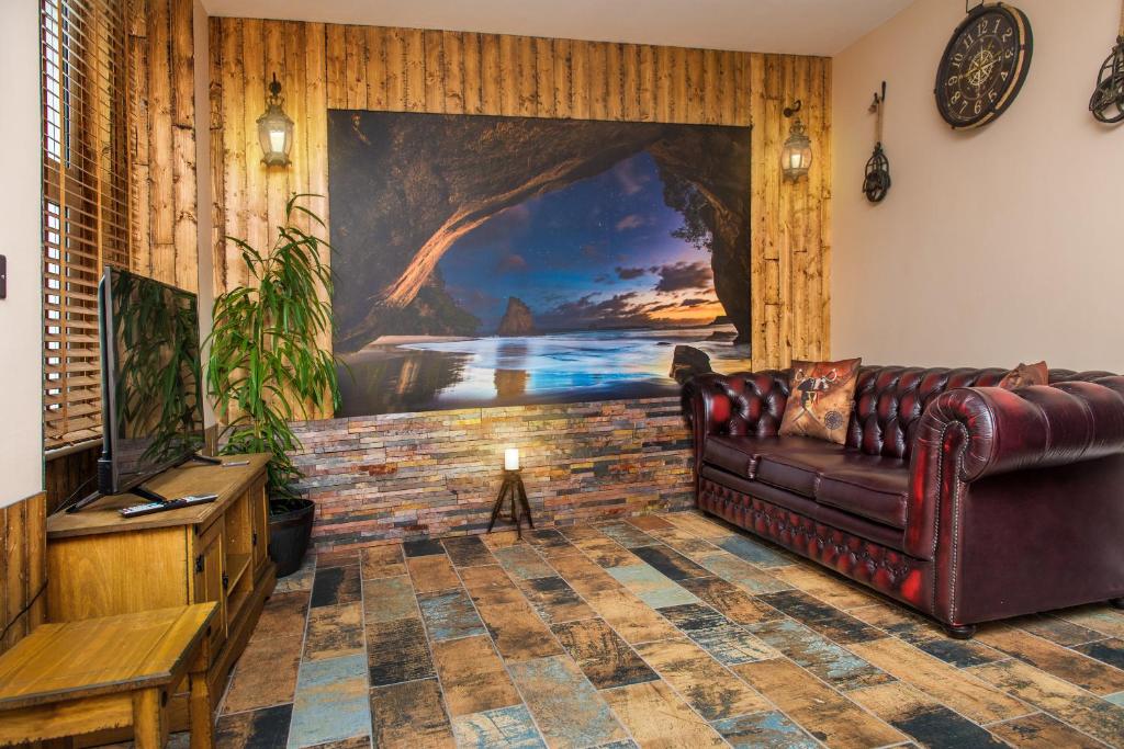 圣奥斯特尔Deluxe Pirate's Cove Themed Apartment的客厅配有真皮沙发和绘画