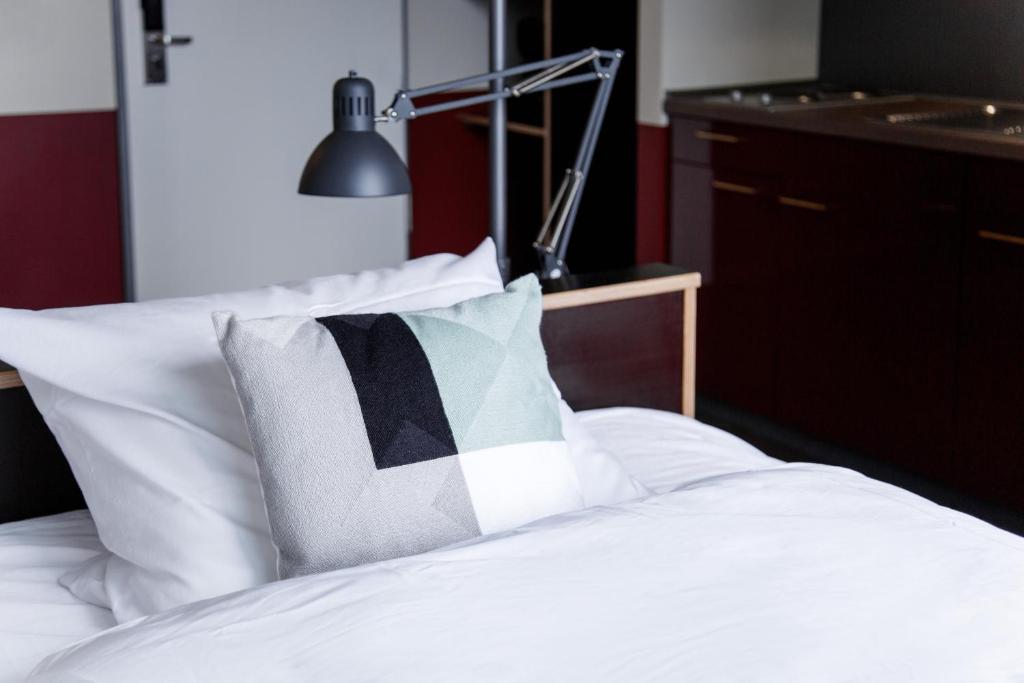 汉堡Base Apartments的一张带黑白枕头和灯的床