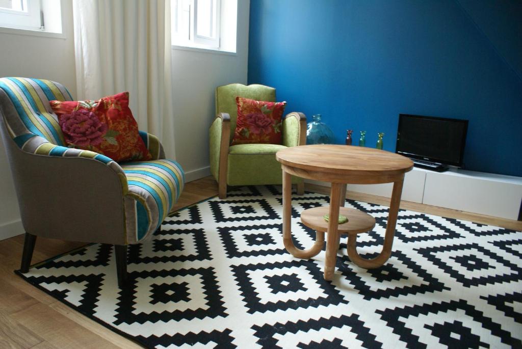 里尔拉考尔苏博思品酒店的客厅配有两把椅子、一张桌子和电视