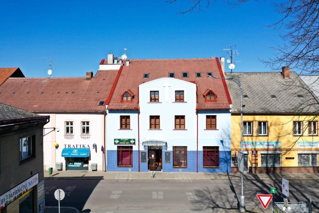 Kostelec nad OrlicíHotel Panský dům的一座白色的大建筑,有红色的屋顶