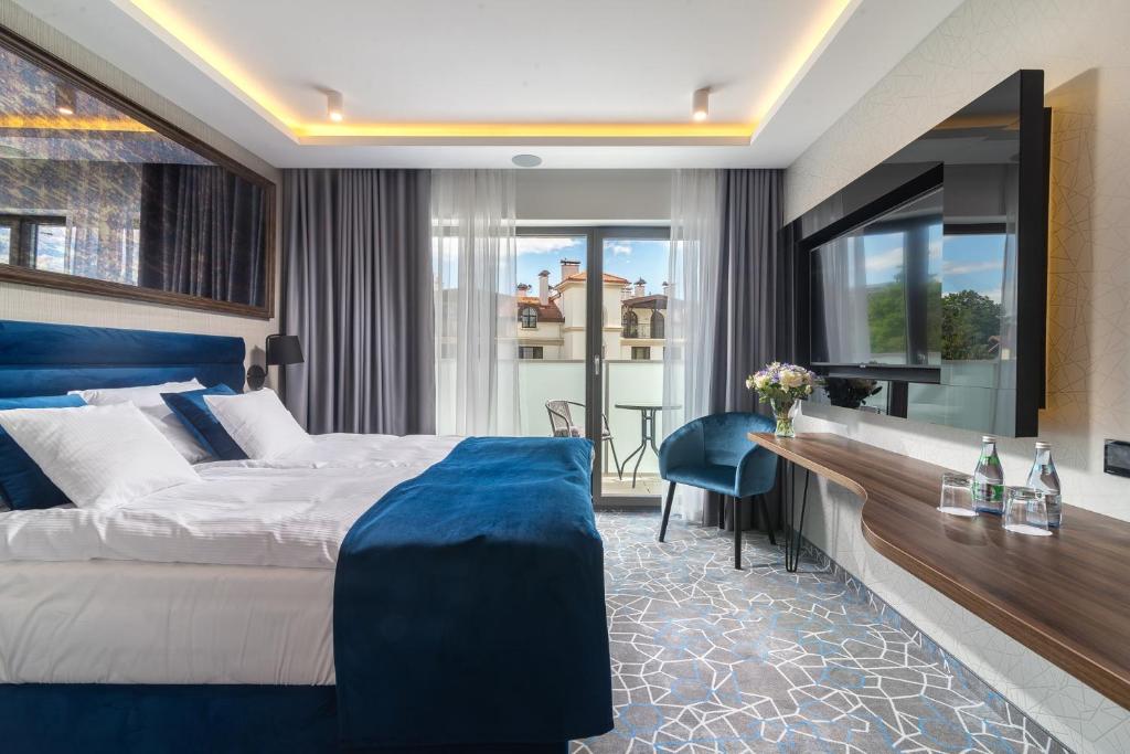 索波特Love Sopot Residence的酒店客房设有一张大床和一张书桌。