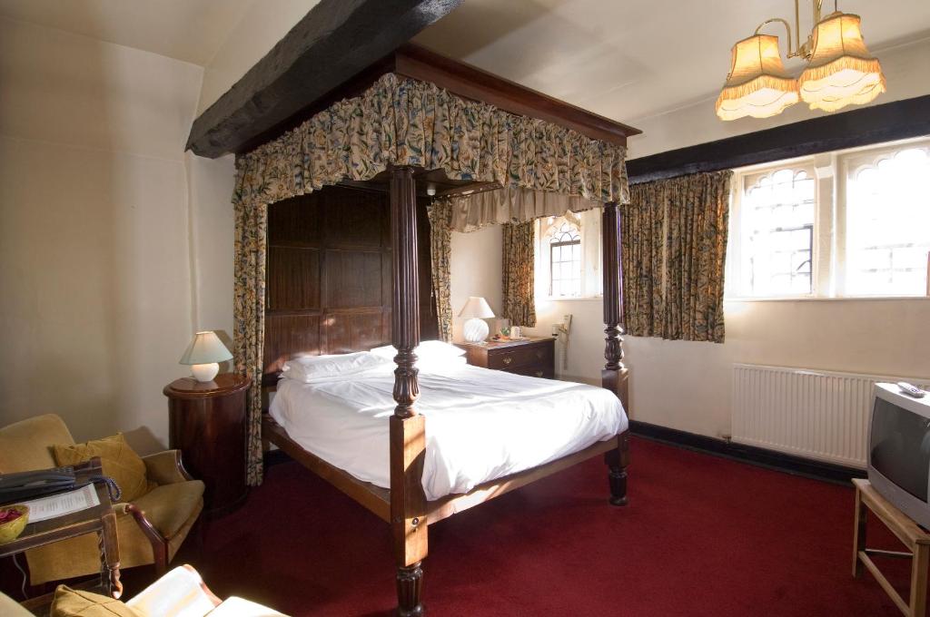 格拉斯顿伯里George & Pilgrims Hotel的一间卧室,卧室内配有一张天蓬床