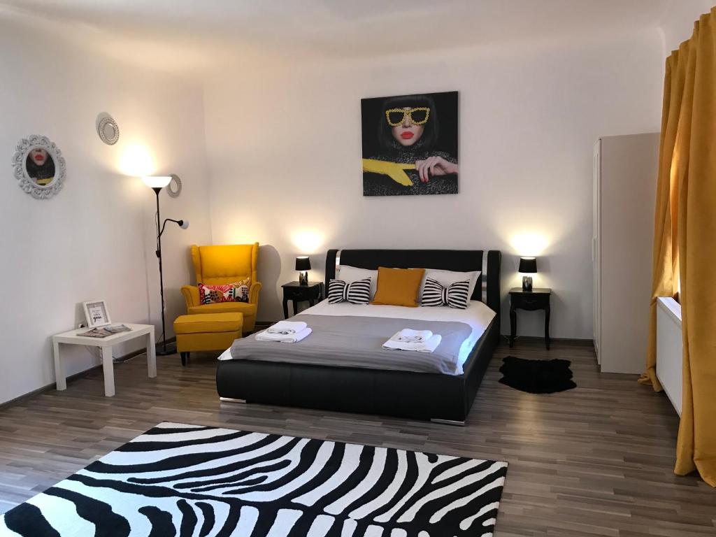 布拉索夫9 Central Residence的一间卧室配有一张床和一张黄色椅子