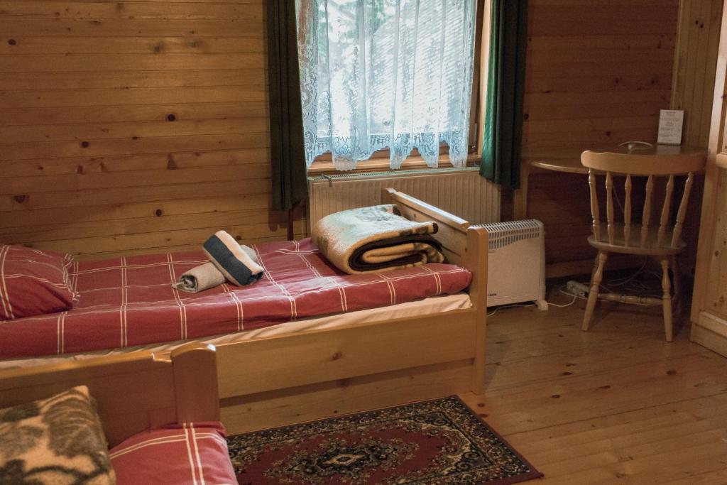 Lovrenc na PohorjuPENZIJON URBANC的卧室配有床、椅子和窗户。