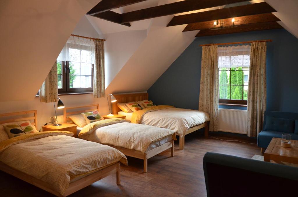 FredropolAgroturystyka Leśny Potok的阁楼卧室配有两张床和一张蓝色椅子