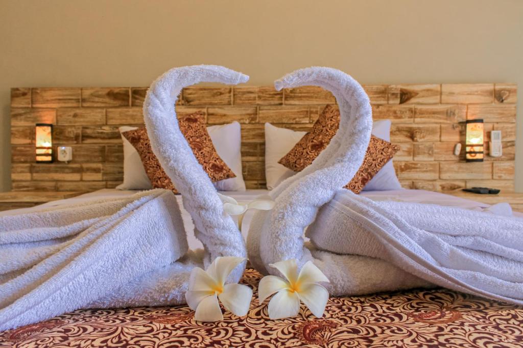 JembranaHotel Niki的一张带两个天鹅的毛巾床