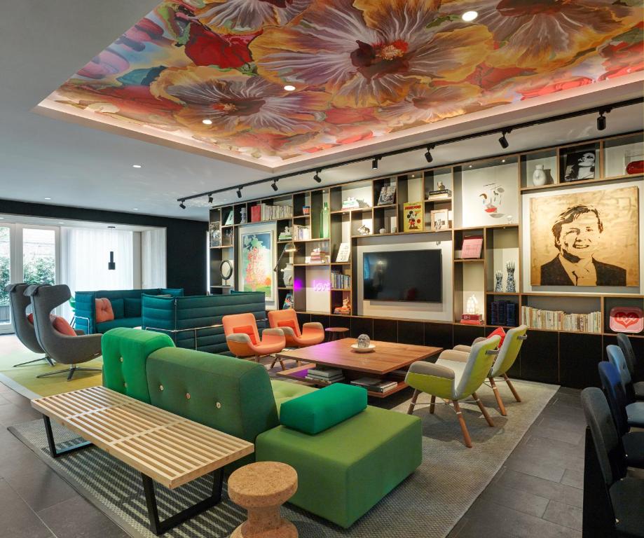 阿姆斯特丹citizenM Amstel Amsterdam的客厅配有色彩缤纷的家具和电视。