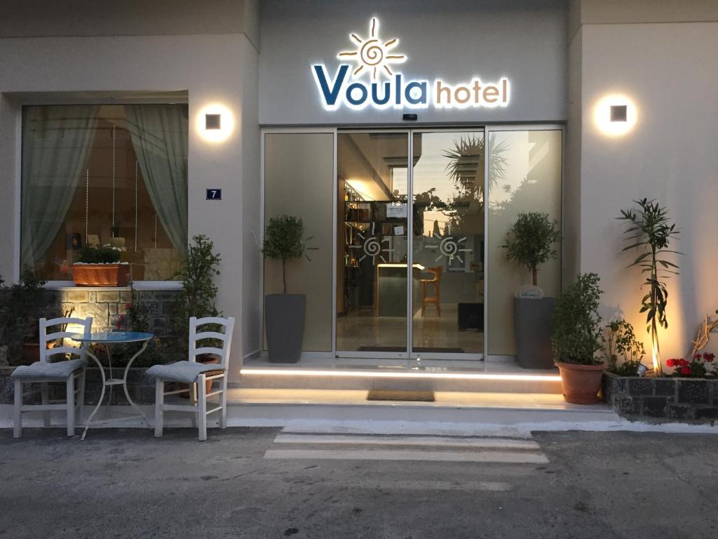 赫索尼索斯Voula Hotel的弗鲁拉酒店前方设有桌椅
