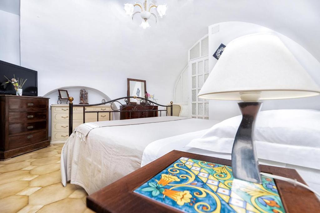 阿特拉尼Il Nido Casa Vacanze的一间卧室配有一张床和一张带台灯的桌子