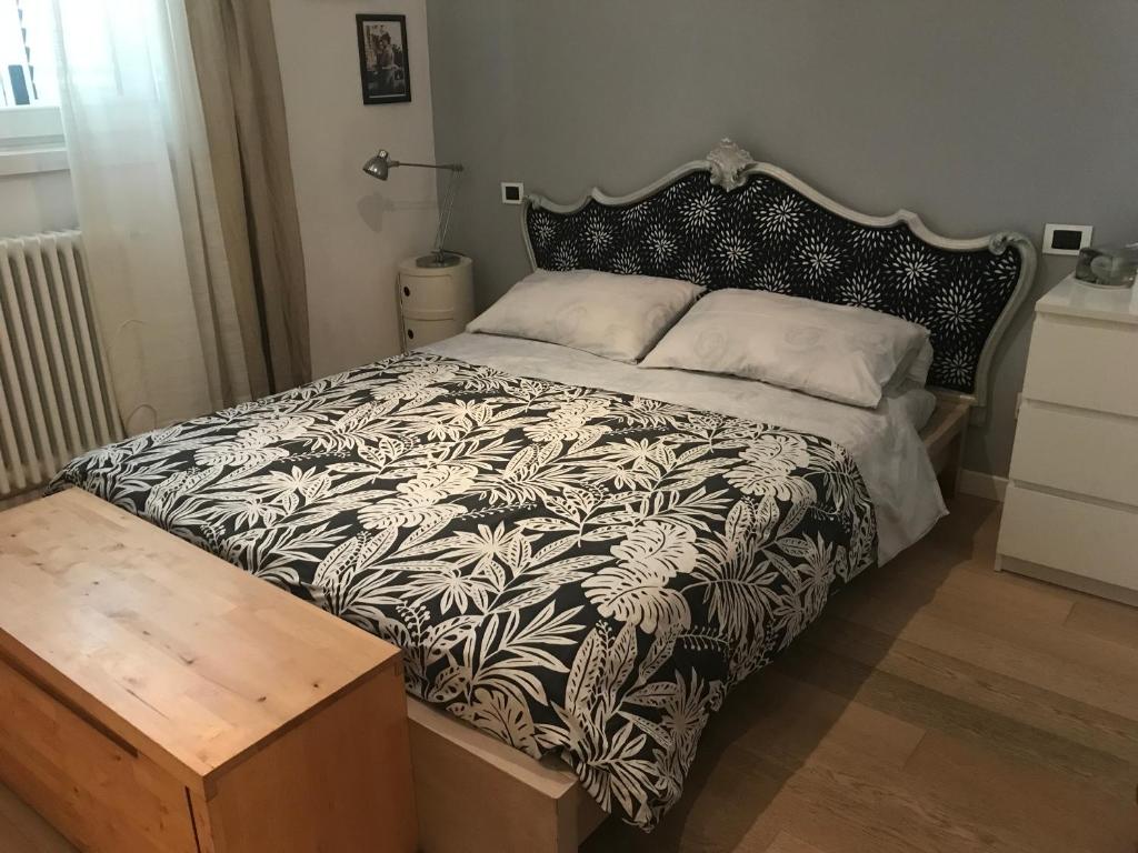 卢卡camera con bagno privato e parcheggio的一间卧室配有一张带黑白色棉被的床