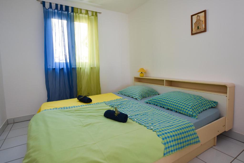 库斯提奇Apartman Rosa 2的卧室设有两张蓝色和绿色的床