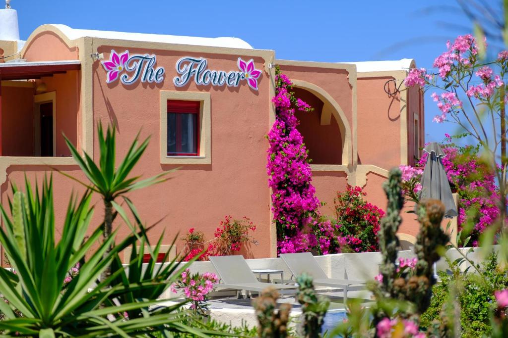伊亚Pension The Flower的粉红色的建筑,上面有读花的标志