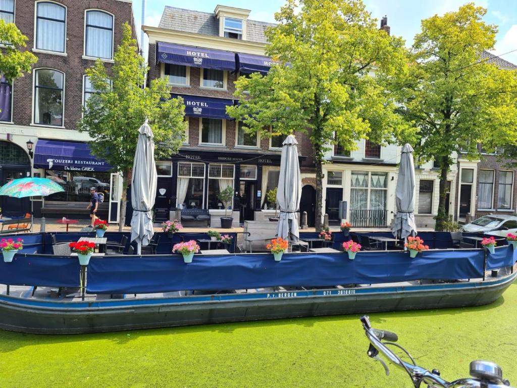 代尔夫特Hotel Bridges House Delft的一条蓝色的船,在河上放着遮阳伞