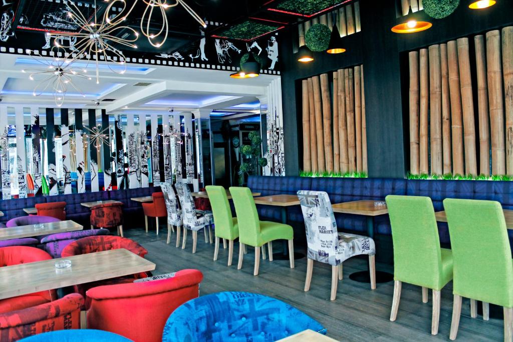 贝尔格莱德ESTRADA Lux的一间餐厅,房间内设有五颜六色的椅子和桌子