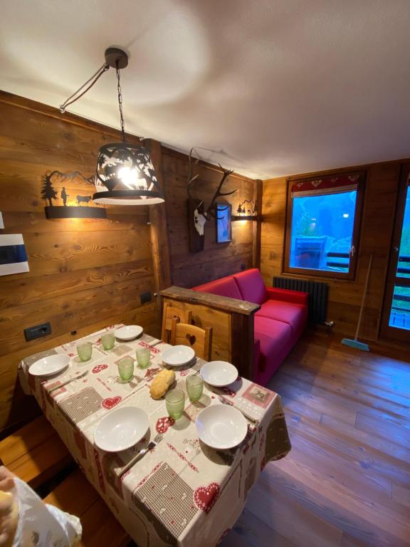布勒伊-切尔维尼亚Baita delle marmotte CIR n 0012的客厅配有桌子和红色沙发