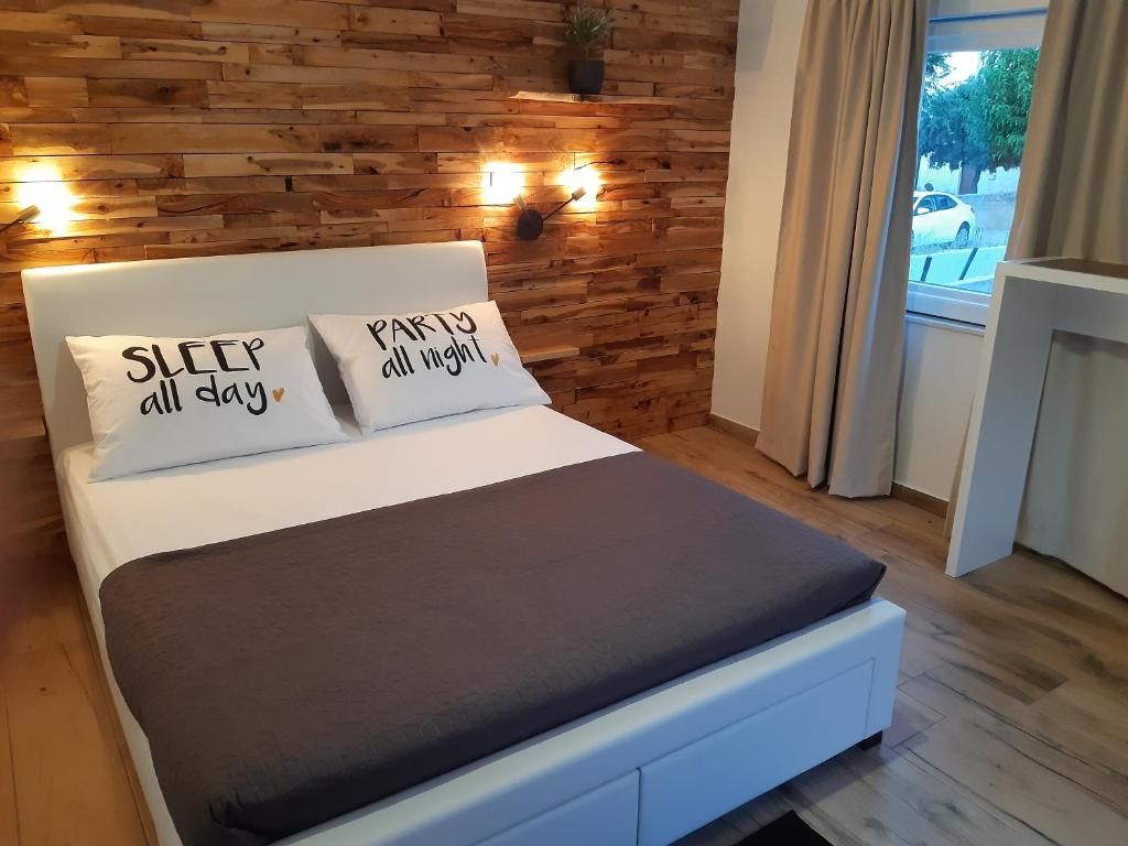 萨利little olive tree house的一间卧室配有带枕头的床铺和木墙