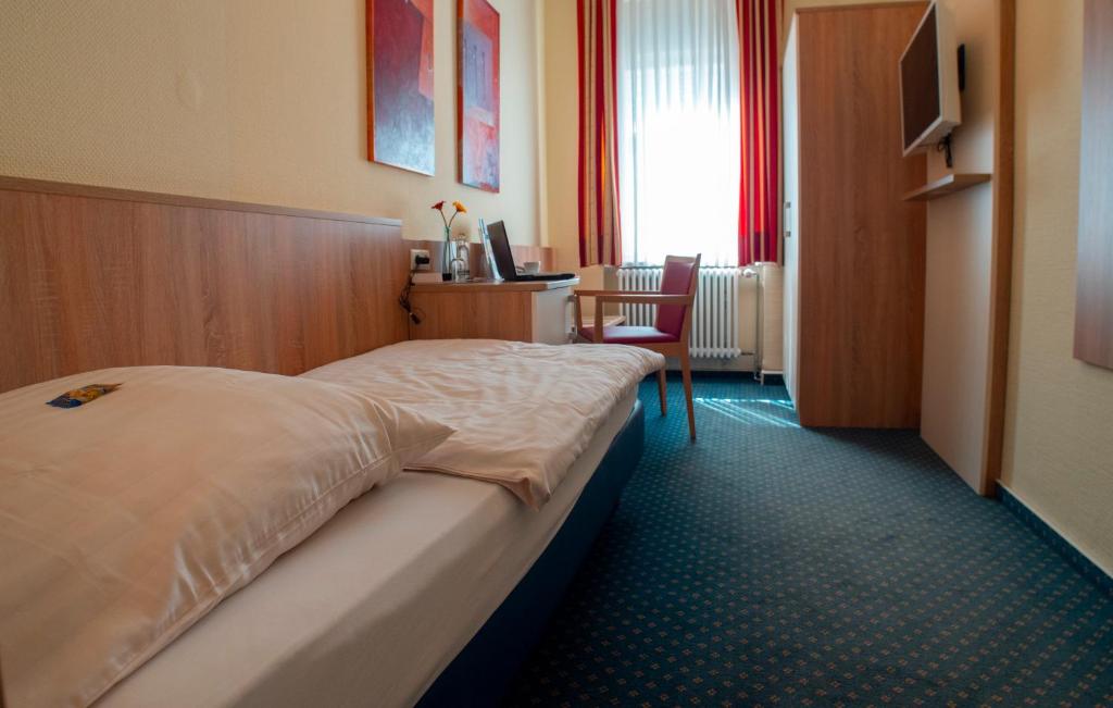 科布伦茨特里尔酒店的配有一张床和一张书桌的酒店客房