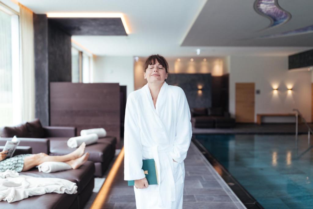 奥伯林塔尔的里德图因霍夫酒店的身着浴袍的女人站在游泳池旁