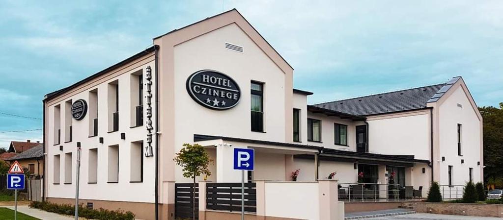 KókaHotel Czinege & Étterem的酒店大楼的一侧有标志