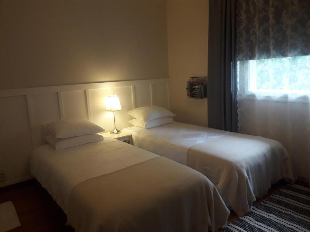 LiminkaMinnan majoitus的配有窗户的酒店客房内的两张床
