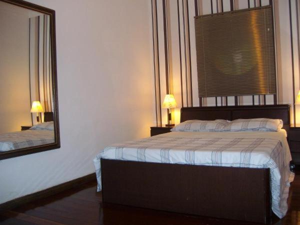 贝洛奥里藏特Apartamento com Hidro的一间卧室配有一张床和一面大镜子