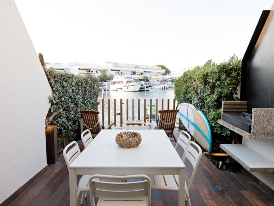勒格罗-迪鲁瓦Marina NS Guesthouse的河面阳台的白色桌椅
