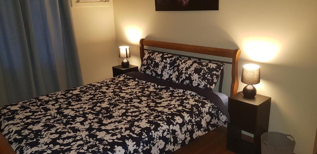 怀阿拉Warmont Apartments Self Contained Home的一间卧室配有一张带两盏灯的黑白床。