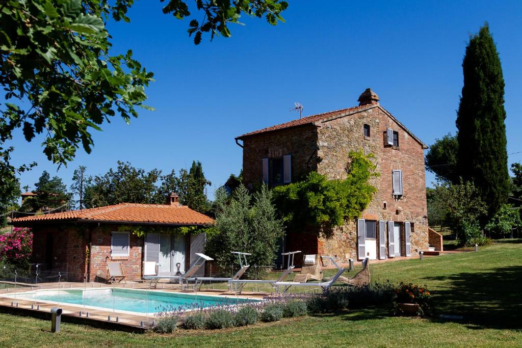 Marciano Della ChianaLa Bacaia的房屋前有游泳池的建筑